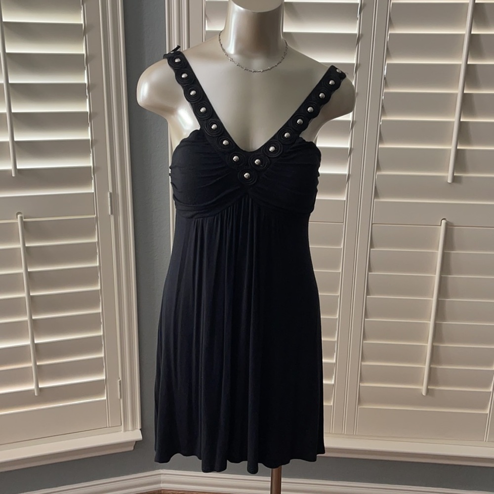 Black dress adorned with silver studs on blunging V-neck line